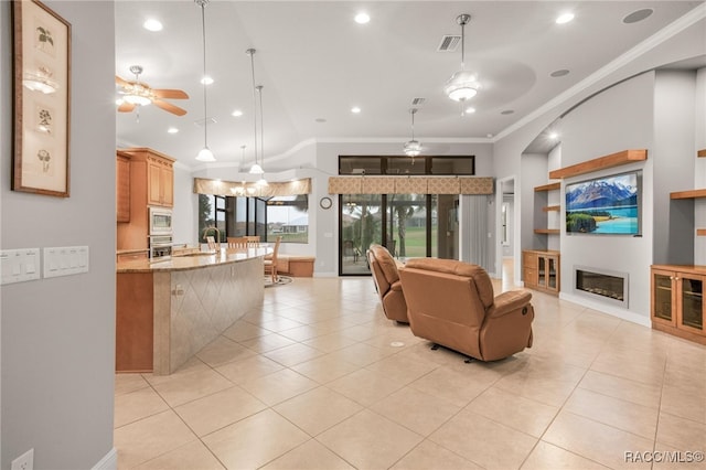 tiled living room with ornamental molding, ceiling fan, sink, and built in shelves