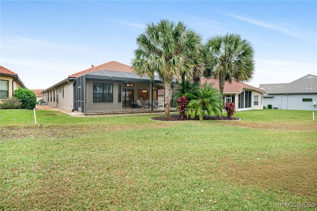 back of property featuring a lawn and a lanai