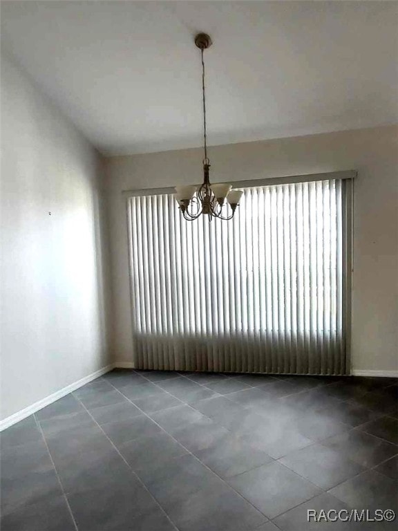 unfurnished dining area with tile patterned floors, baseboards, and an inviting chandelier
