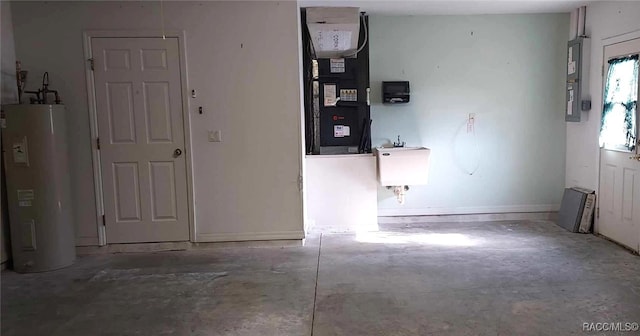 interior space with water heater, electric panel, heating unit, and a sink