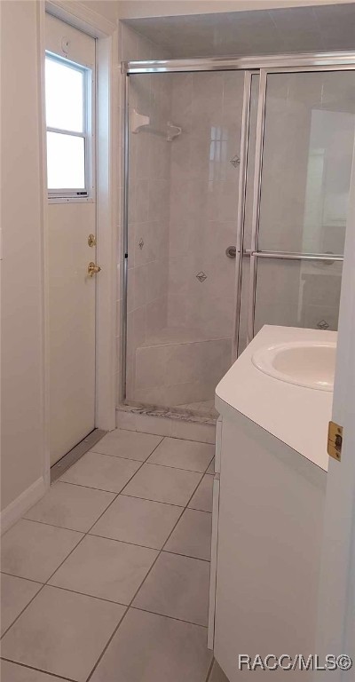 bathroom with vanity, tile patterned flooring, and a stall shower