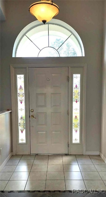 entryway with baseboards and light tile patterned floors