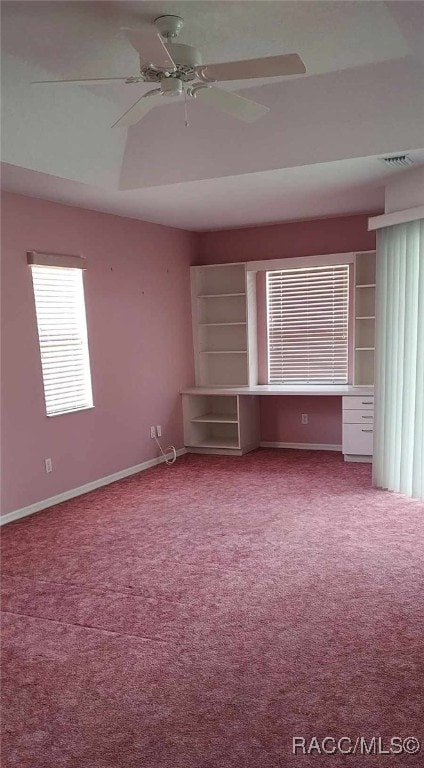 carpeted spare room featuring baseboards, a ceiling fan, and visible vents