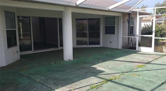 view of patio featuring glass enclosure