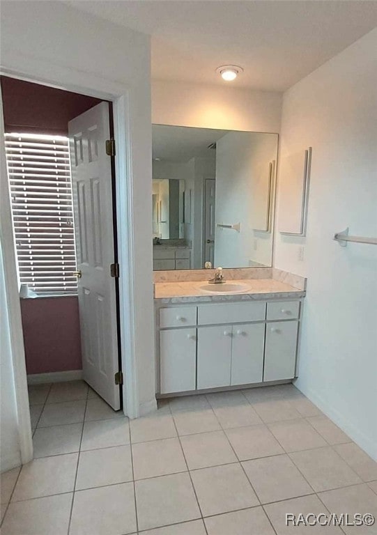 bathroom featuring vanity, baseboards, and tile patterned flooring