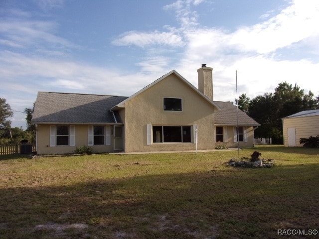 back of house with a lawn