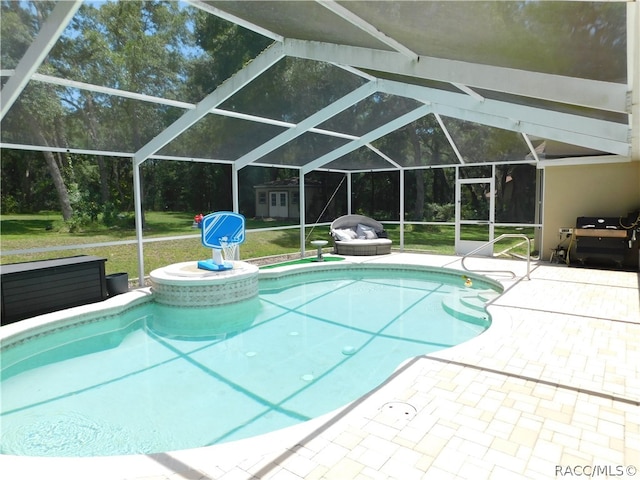 view of pool with a patio area, a grill, a yard, and glass enclosure