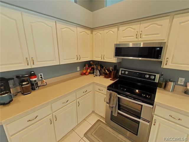 kitchen with light tile patterned floors and stainless steel appliances