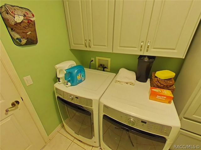 laundry area featuring cabinets, light tile patterned flooring, and washer and dryer