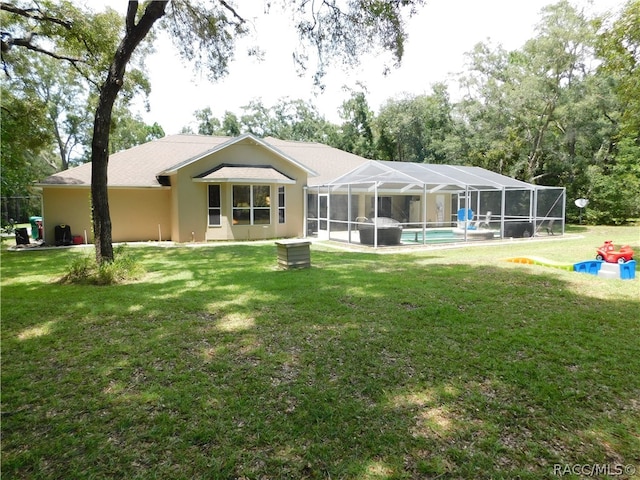 rear view of house featuring a lanai and a yard