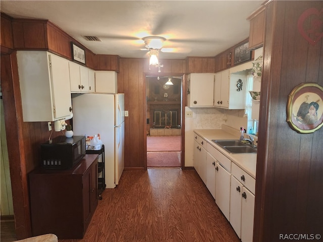 kitchen with white refrigerator, white cabinetry, dark wood-type flooring, and sink