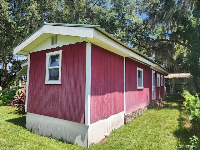 view of home's exterior featuring a lawn and an outdoor structure