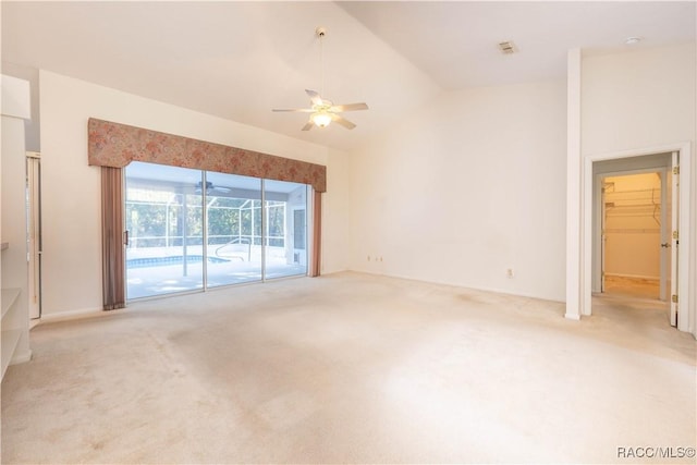 unfurnished living room with high vaulted ceiling, light colored carpet, and ceiling fan