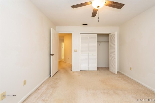 unfurnished bedroom featuring ceiling fan, a closet, and light carpet