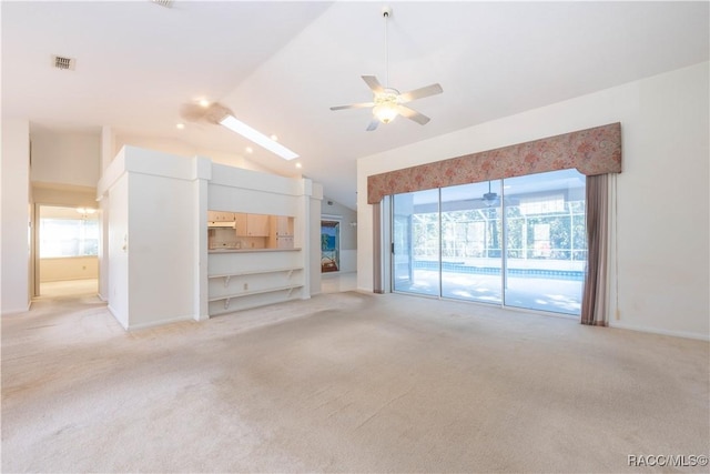 unfurnished living room featuring ceiling fan, light colored carpet, and vaulted ceiling