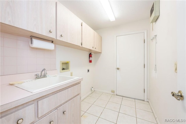 laundry area featuring sink, cabinets, light tile patterned floors, electric dryer hookup, and washer hookup