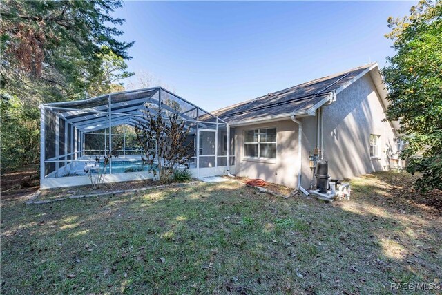 back of property featuring a yard and a lanai