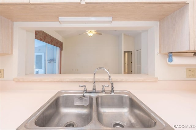 kitchen featuring vaulted ceiling, sink, ceiling fan, and light brown cabinetry