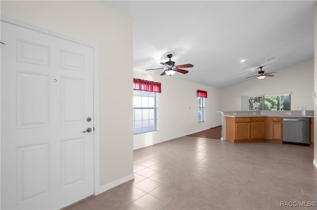 kitchen featuring dishwasher, vaulted ceiling, plenty of natural light, and light tile patterned flooring