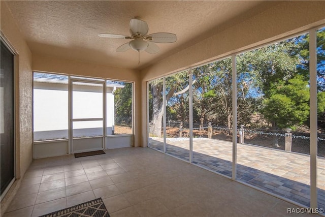 unfurnished sunroom featuring ceiling fan