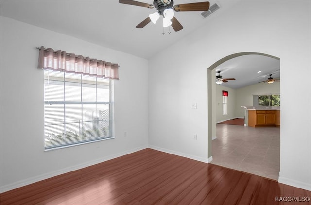 empty room featuring ceiling fan, wood-type flooring, and lofted ceiling