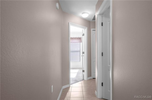 hall featuring light tile patterned floors