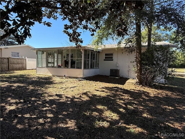 rear view of property featuring a sunroom and central AC