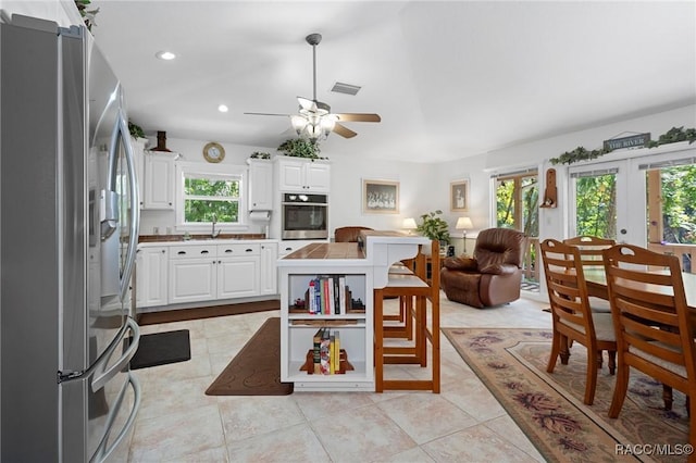 kitchen featuring french doors, visible vents, appliances with stainless steel finishes, white cabinetry, and a sink