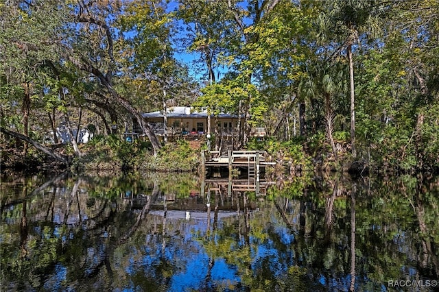 exterior space with a water view, a view of trees, and stairs