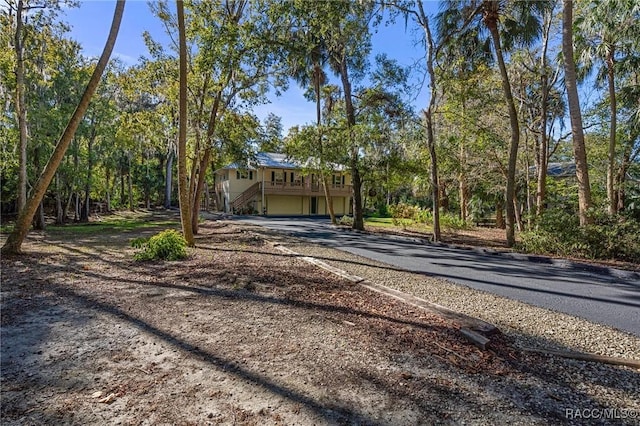 view of front of property with driveway, a garage, and stairway