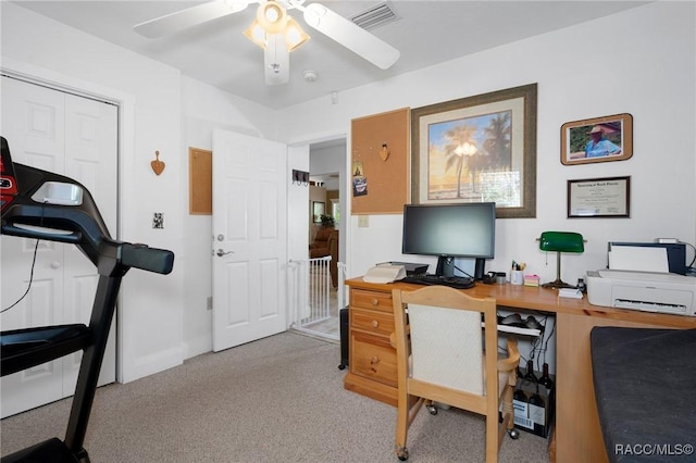 home office featuring carpet, visible vents, and a ceiling fan