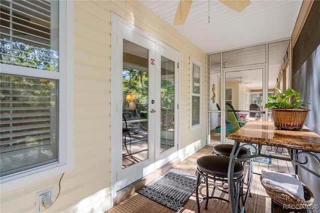 sunroom with a ceiling fan, french doors, and plenty of natural light