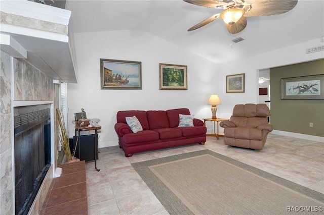 living area featuring lofted ceiling, tile patterned flooring, a fireplace, a ceiling fan, and baseboards