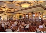 dining area with beamed ceiling, bar, and coffered ceiling