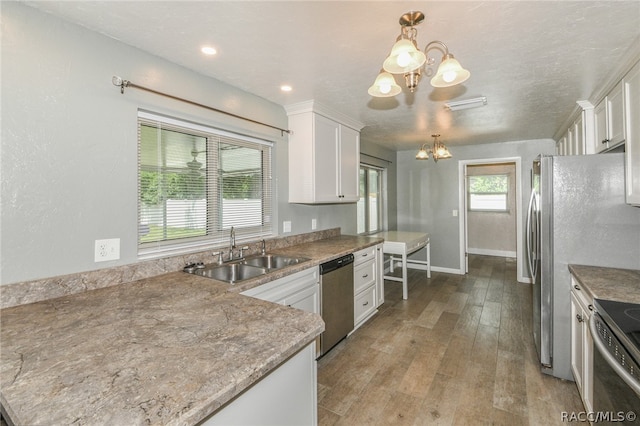 kitchen featuring decorative light fixtures, white cabinetry, and sink