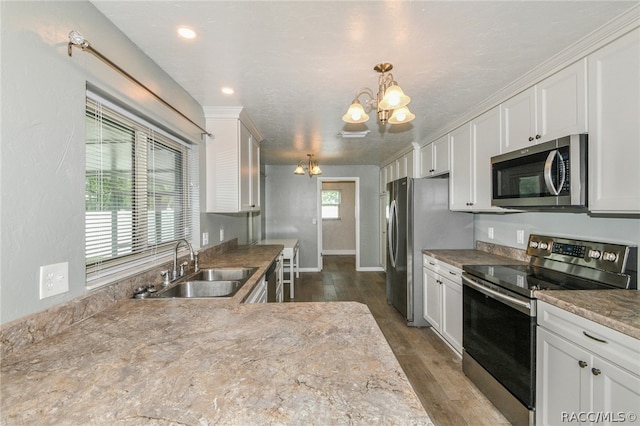 kitchen featuring sink, a notable chandelier, dark hardwood / wood-style flooring, white cabinetry, and stainless steel appliances