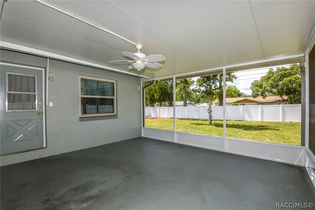 unfurnished sunroom featuring ceiling fan and a wealth of natural light