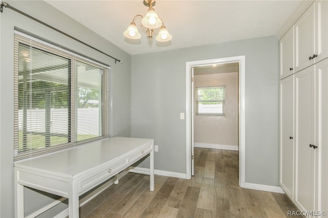 unfurnished dining area with light hardwood / wood-style flooring and a notable chandelier