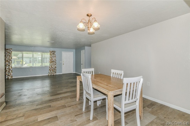 dining space featuring hardwood / wood-style floors and a chandelier