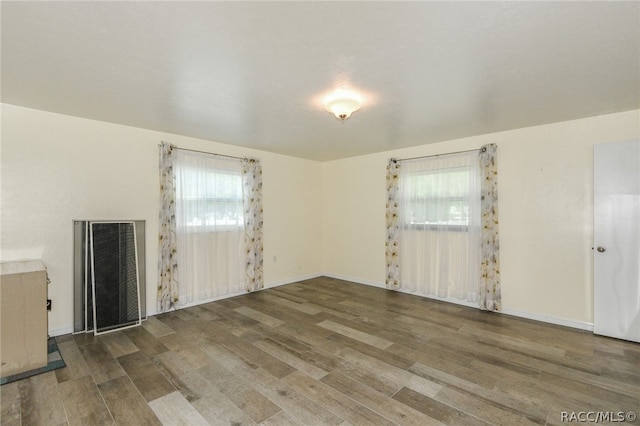 unfurnished room with a healthy amount of sunlight and wood-type flooring