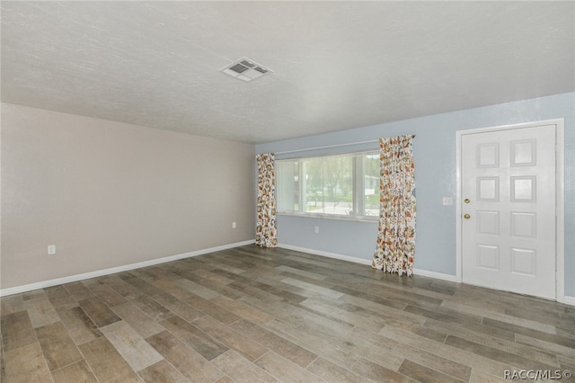 interior space featuring wood-type flooring and a textured ceiling