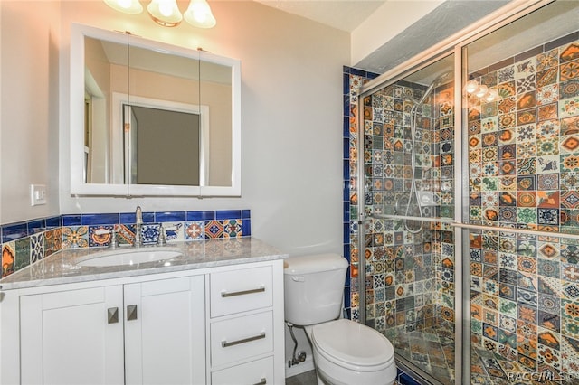 bathroom featuring vanity, toilet, and an enclosed shower