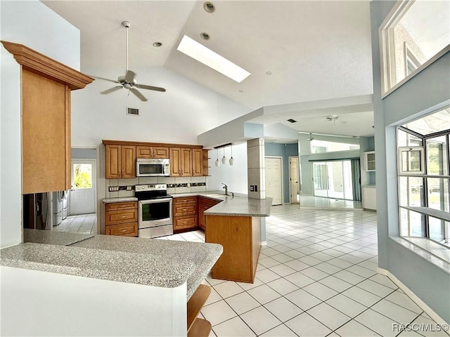 5725 N Durango Ter, Beverly Hills, FL 34465 - kitchen with appliances with stainless steel finishes, a peninsula, high vaulted ceiling, open floor plan, and brown cabinetry