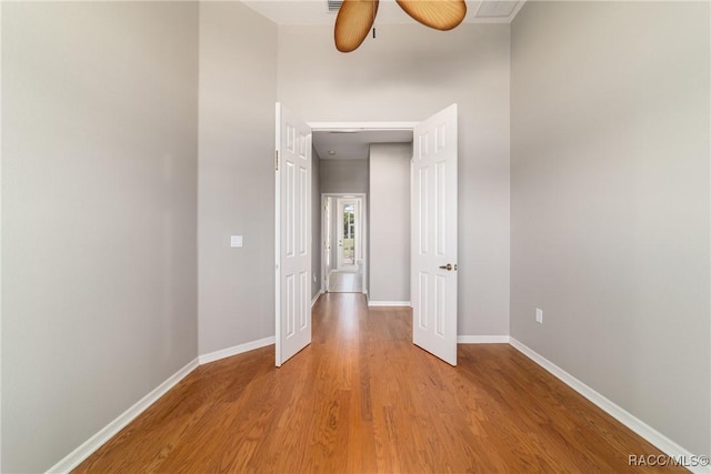 corridor with wood finished floors and baseboards