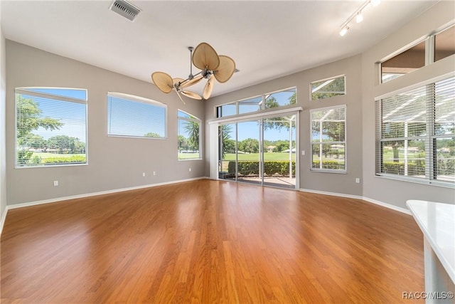 spare room featuring baseboards, a wealth of natural light, visible vents, and track lighting