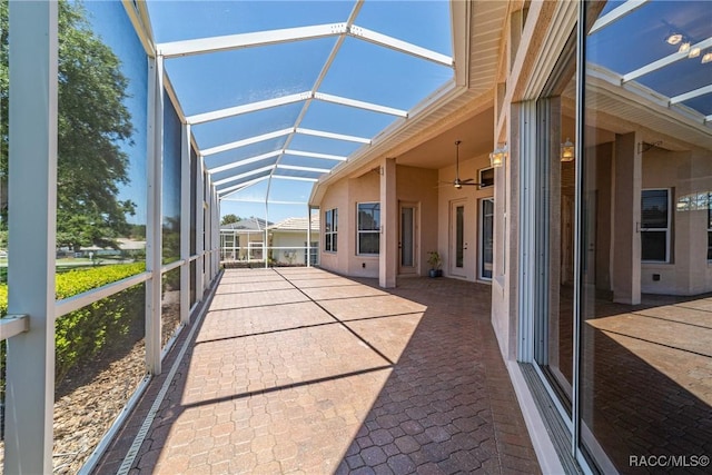 unfurnished sunroom with a ceiling fan