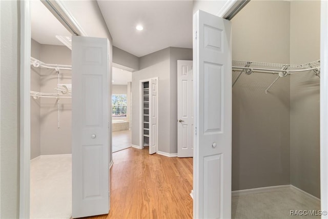 walk in closet with light wood-style floors