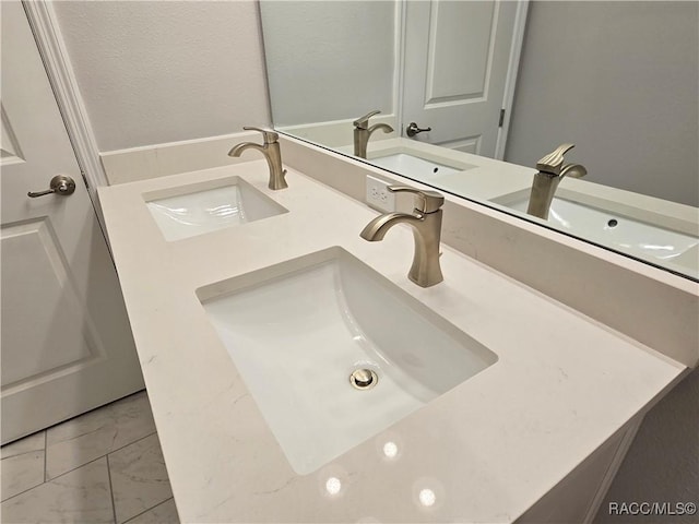 bathroom featuring a sink, double vanity, and marble finish floor
