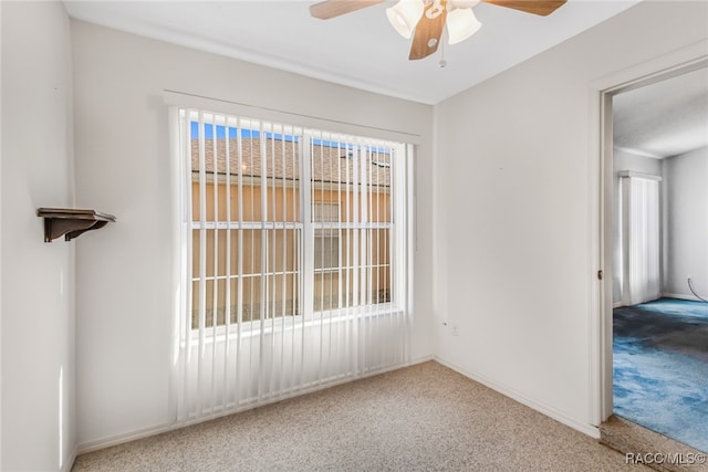 carpeted spare room featuring a wealth of natural light and ceiling fan