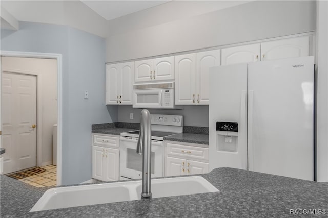 kitchen with lofted ceiling, white cabinetry, and white appliances